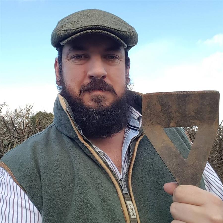 Anton de Beer, The Kentish Gardener, outdoors in his flat cap and gardening waistcoat